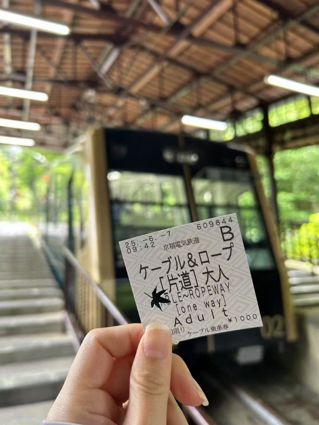 手拿琵琶湖山谷缆车票，背景是候车站台