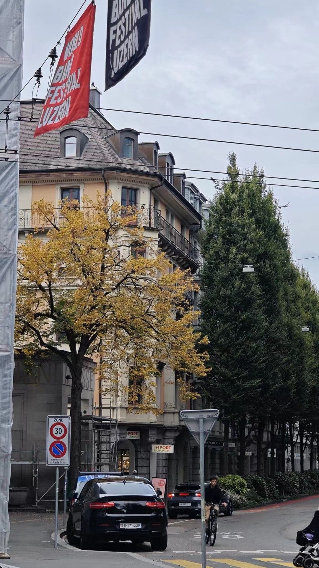 卢塞恩街角建筑，瑞士旗挂在外墙上，远处可见湖面