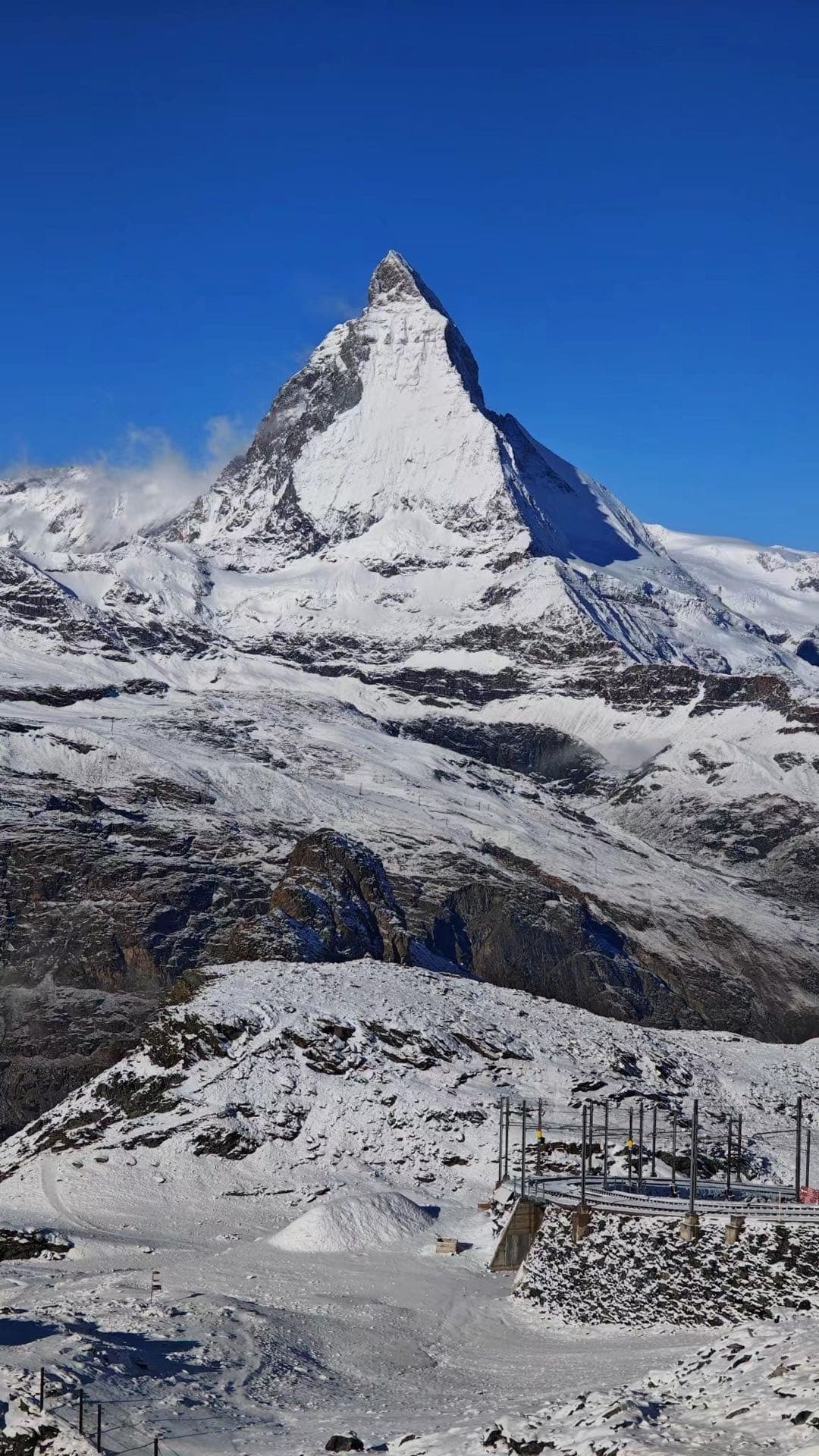 雪坡前方的马特洪峰，山体在晴空下呈清晰三角形