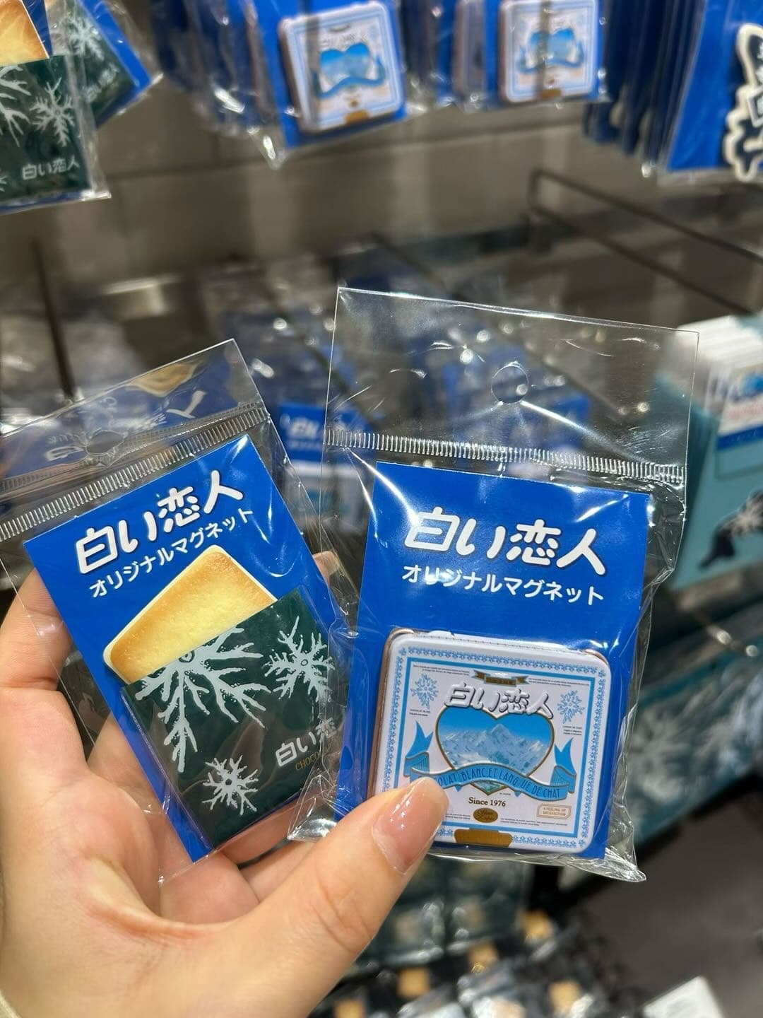 手拿多包白色恋人小包装，背景是店内货架